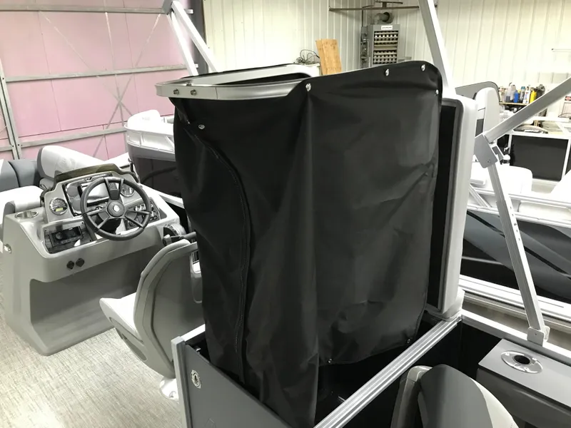 Slide: The Image of 2025 Avalon GEOfish REAR FISH boat interior with steering wheel and covered equipment. - 25