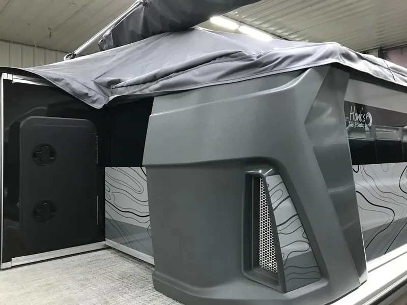 Slide: The Image of 2025 Avalon GEOfish REAR FISH boat, sleek design, covered, in a garage setting. - 43