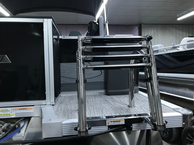 Slide: The Image of 2025 Avalon GEOfish REAR FISH boat with stainless steel ladder in a showroom. - 5