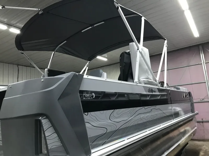 Slide: The Image of 2025 Avalon GEOfish REAR FISH boat with canopy in a garage setting. - 6