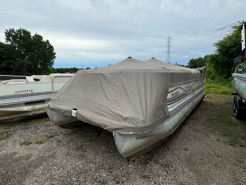 The Image of Covered 2000 Bennington 2275 RL pontoon boat parked on gravel. - 1