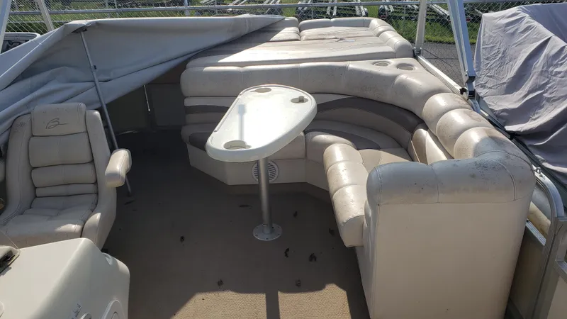 Slide: The Image of 2000 Bennington 2275 RL pontoon boat interior with seating and table. - 2