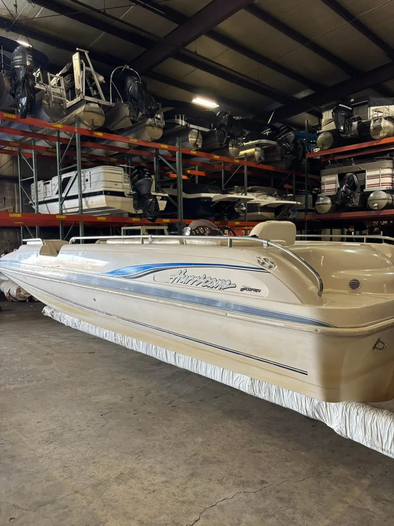 Slide: The Image of 2001 Hurricane FunDeck GS 201 I/O boat in storage, beige with blue accents. - 0