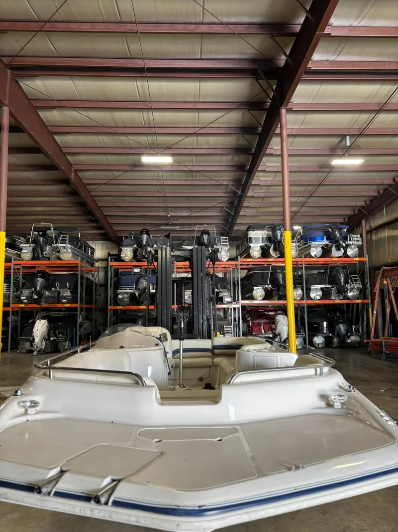 Slide: The Image of 2001 Hurricane FunDeck GS 201 I/O boat stored in a spacious warehouse. - 11