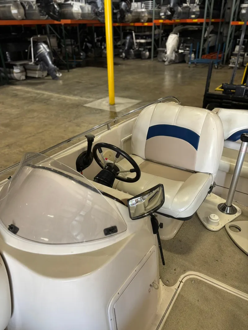 Slide: The Image of 2001 Hurricane FunDeck GS 201 I/O boat interior with steering wheel and seating in a warehouse. - 2