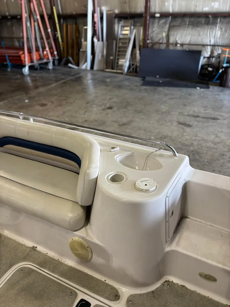 Slide: The Image of 2001 Hurricane FunDeck GS 201 I/O boat interior with seating and cup holders in a warehouse. - 4