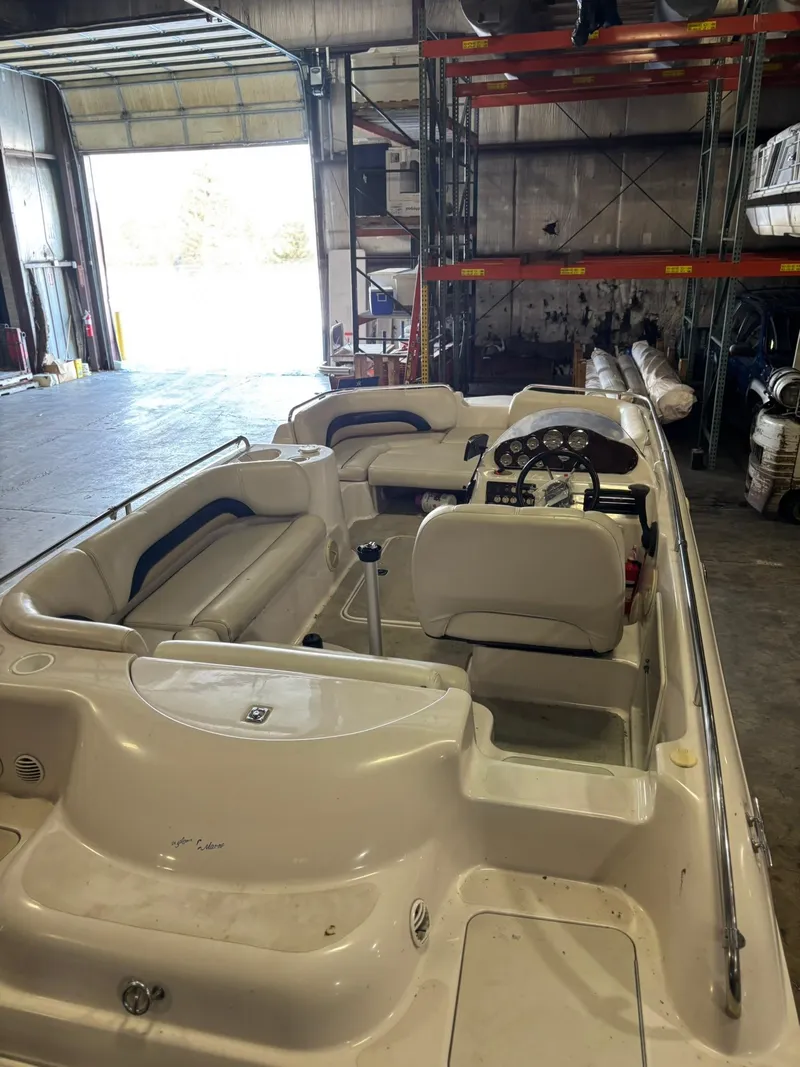 Slide: The Image of 2001 Hurricane FunDeck GS 201 I/O boat in a warehouse, showcasing interior seating and controls. - 6