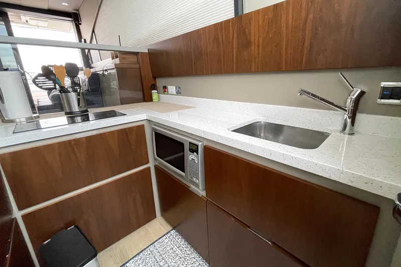 Slide: The Image of Modern kitchen in 2015 Fairline Targa 62 GT yacht with sleek countertops and wooden cabinetry. - 12