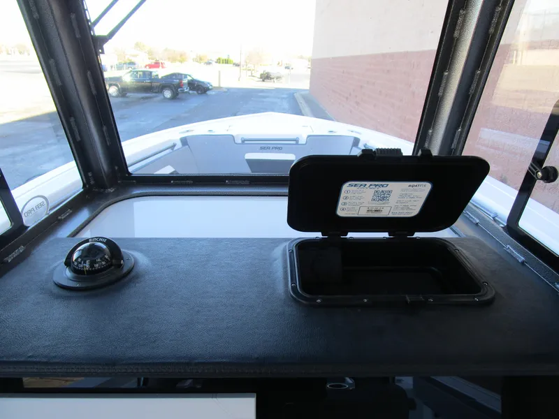 Slide: The Image of 2025 Sea Pro 292 Offshore dashboard with compass and storage compartment. - 23
