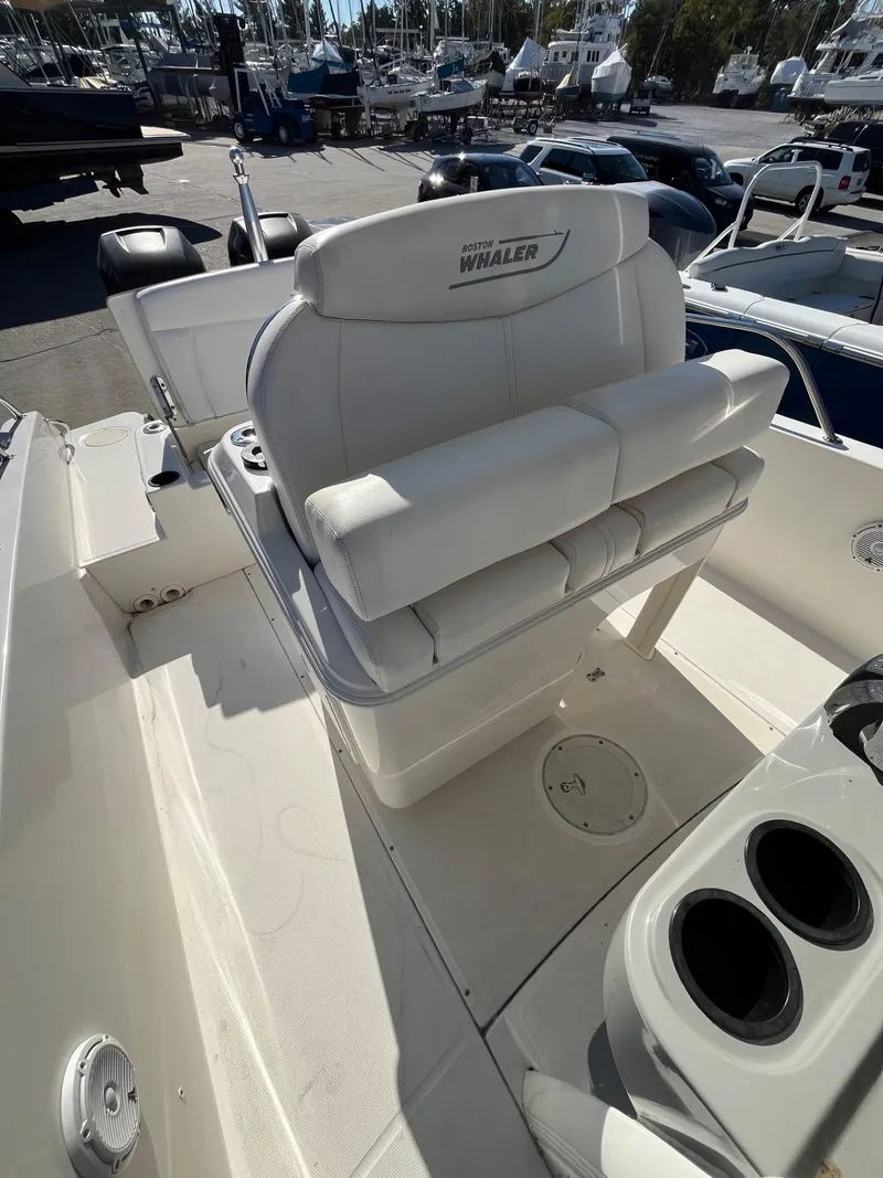 Slide: The Image of 2014 Boston Whaler 270 Dauntless boat interior with cushioned seating and cup holders. - 17