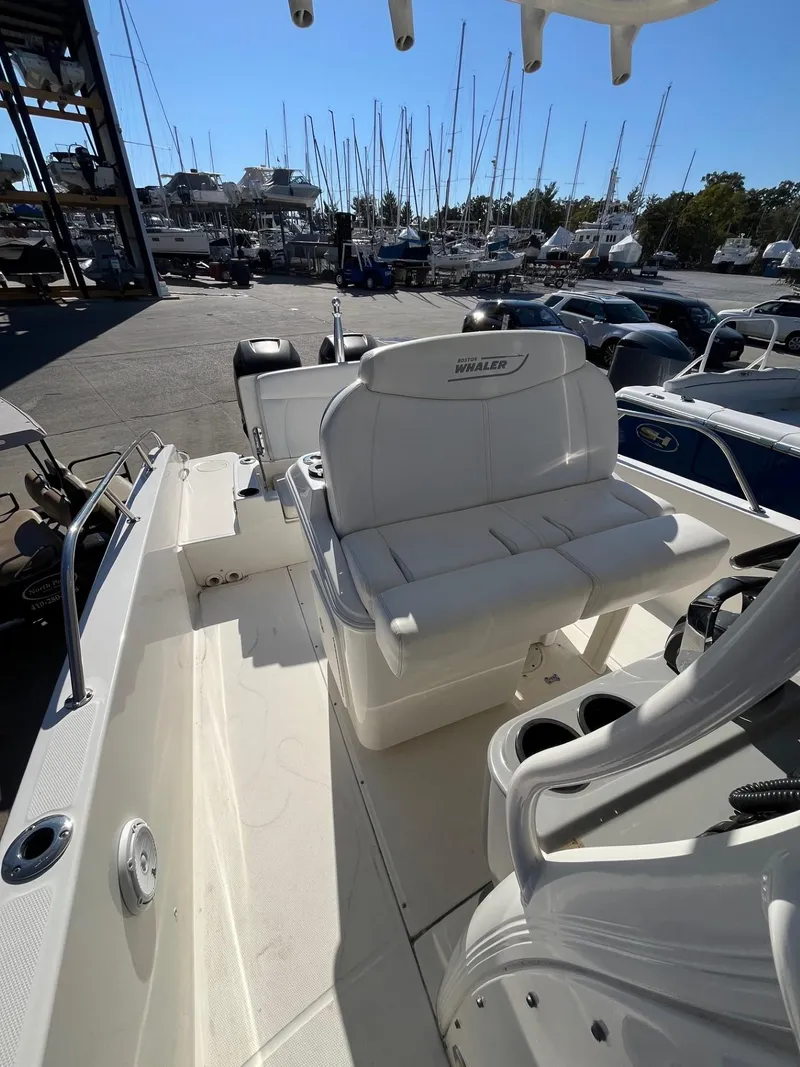 Slide: The Image of 2014 Boston Whaler 270 Dauntless boat interior with seating, docked at marina. - 20