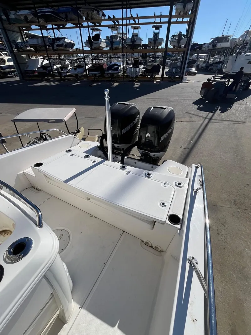 Slide: The Image of 2014 Boston Whaler 270 Dauntless boat with dual engines in a marina setting. - 23