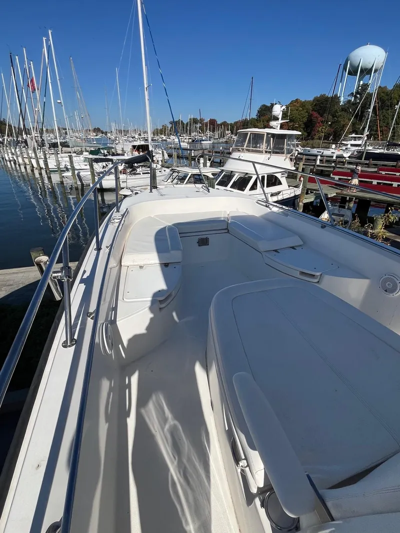 Slide: The Image of 2014 Boston Whaler 270 Dauntless docked at marina, surrounded by sailboats. - 6