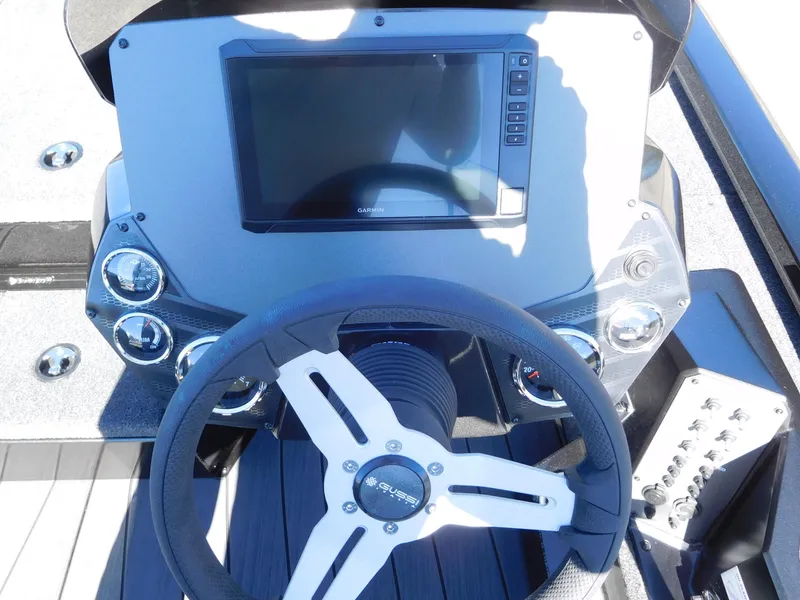 Slide: The Image of 2025 Vexus AVX 1985s boat dashboard with steering wheel and digital display. - 2