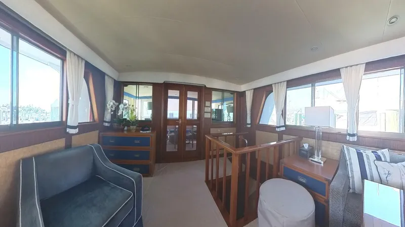 Slide: The Image of Interior of 1982 Hatteras 65 LRC yacht, featuring elegant wood finishes and comfortable seating. - 12