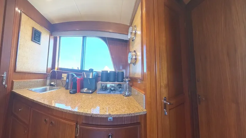 Slide: The Image of Interior of 1982 Hatteras 65 LRC yacht kitchen with wooden cabinetry and modern appliances. - 17