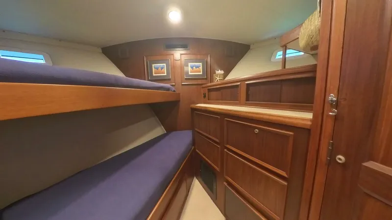 Slide: The Image of 1982 Hatteras 65 LRC cabin with wooden interior and bunk beds. - 21