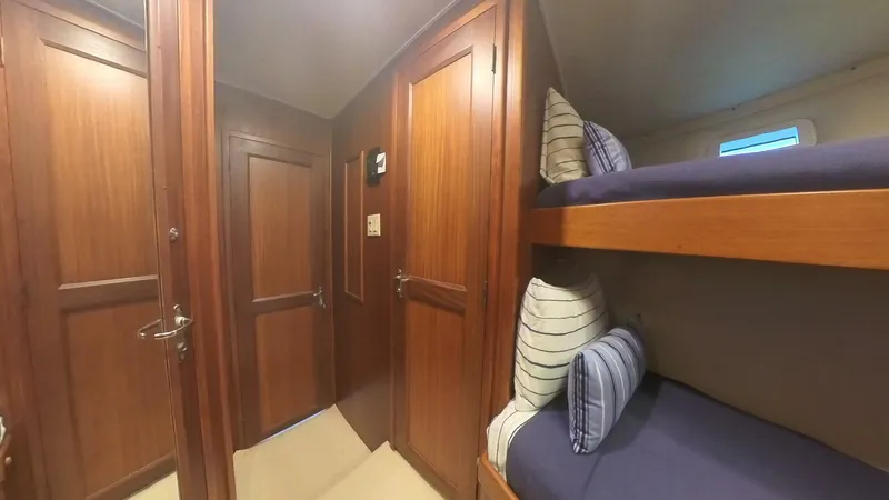 Slide: The Image of Interior of 1982 Hatteras 65 LRC yacht with wooden paneling and bunk beds. - 22