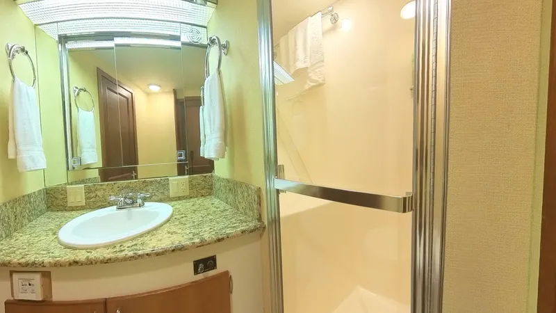 Slide: The Image of Luxurious bathroom in 1982 Hatteras 65 LRC yacht with granite countertop and shower. - 25