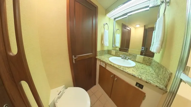 Slide: The Image of 1982 Hatteras 65 LRC yacht bathroom with granite countertop and wooden cabinetry. - 26