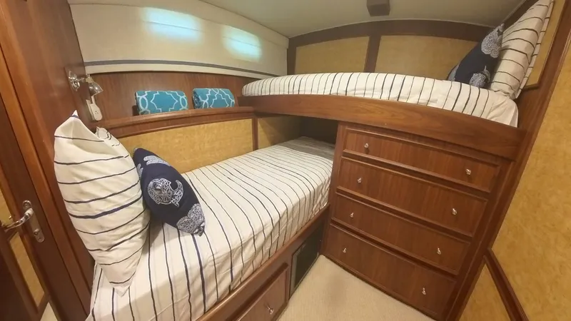 Slide: The Image of Cozy 1982 Hatteras 65 LRC cabin with bunk beds and striped bedding. - 27