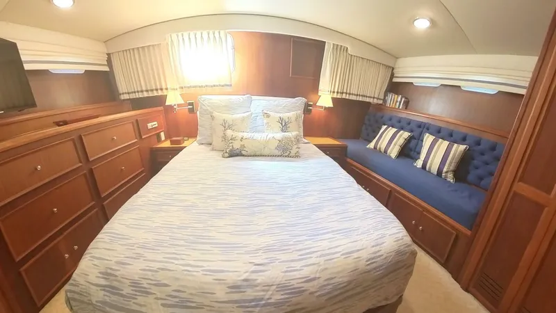 Slide: The Image of Luxurious bedroom interior of 1982 Hatteras 65 LRC yacht with cozy bed and seating area. - 29