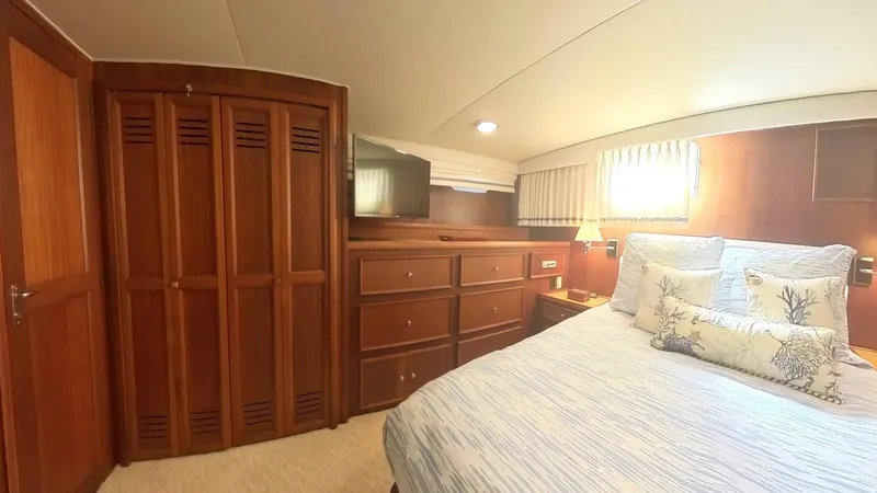 Slide: The Image of Cozy bedroom in 1982 Hatteras 65 LRC yacht with wooden furnishings and soft lighting. - 30