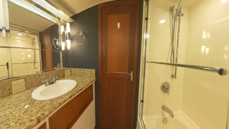 Slide: The Image of Luxurious bathroom in 1982 Hatteras 65 LRC yacht with granite countertop and shower. - 32