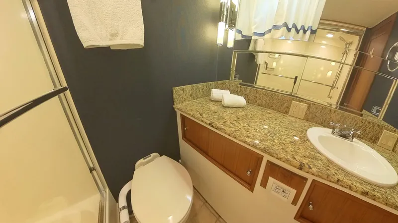 Slide: The Image of Luxurious bathroom in 1982 Hatteras 65 LRC yacht with granite countertop and modern fixtures. - 33