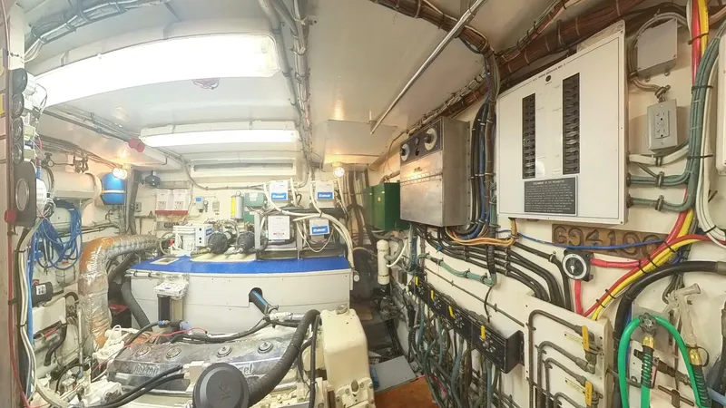 Slide: The Image of Engine room of 1982 Hatteras 65 LRC yacht, featuring complex wiring and machinery. - 36