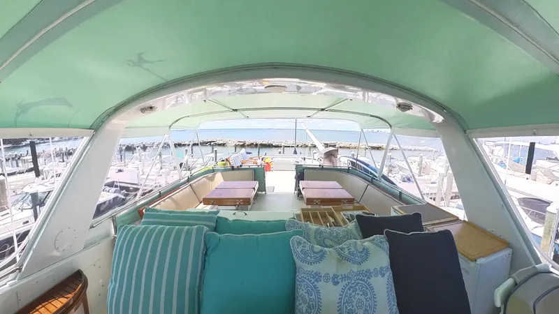 Slide: The Image of 1982 Hatteras 65 LRC yacht interior with cushions and marina view. - 39