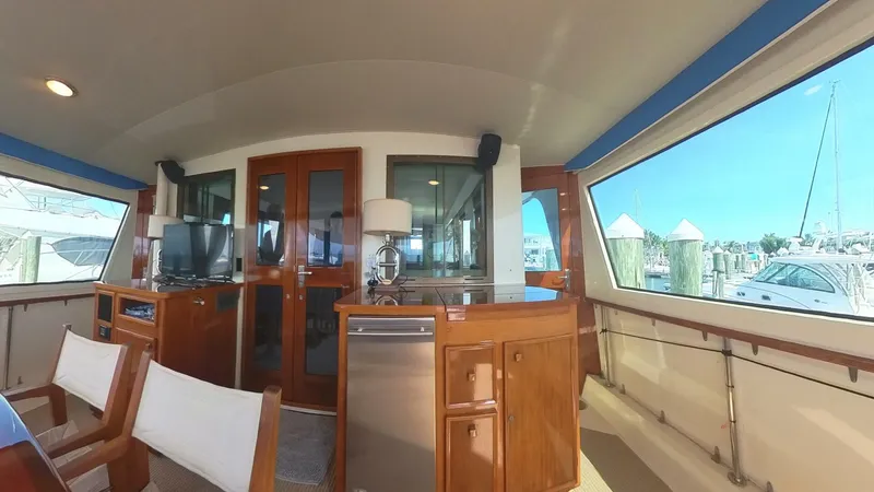 Slide: The Image of Interior of 1982 Hatteras 65 LRC yacht with wooden furnishings and large windows. - 4