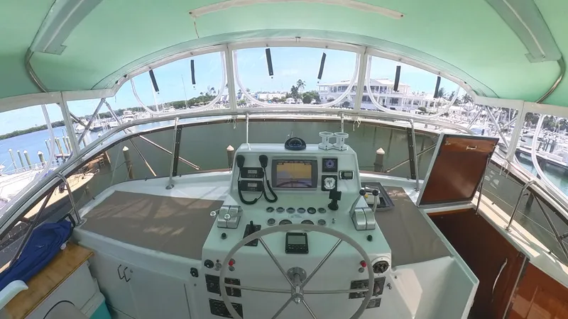 Slide: The Image of Helm of 1982 Hatteras 65 LRC yacht with navigation equipment and panoramic marina view. - 40
