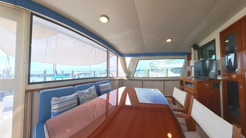 Slide: The Image of Interior of 1982 Hatteras 65 LRC yacht with dining area and large windows. - 5