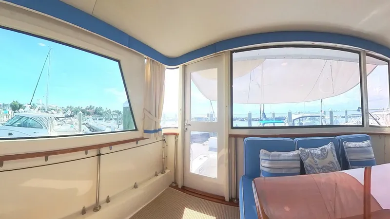 Slide: The Image of Interior view of 1982 Hatteras 65 LRC yacht with marina backdrop. - 6