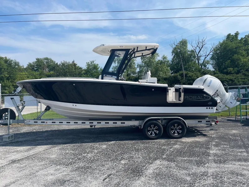The Image of 2025 Robalo R250 Center Console boat on trailer, parked outdoors. - 0