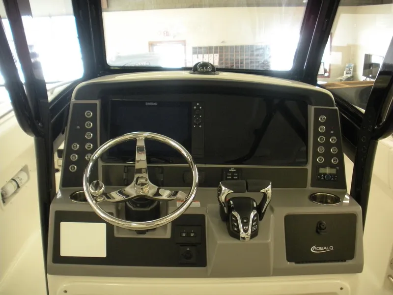 Slide: The Image of 2025 Robalo R250 Center Console boat dashboard with steering wheel and controls. - 14