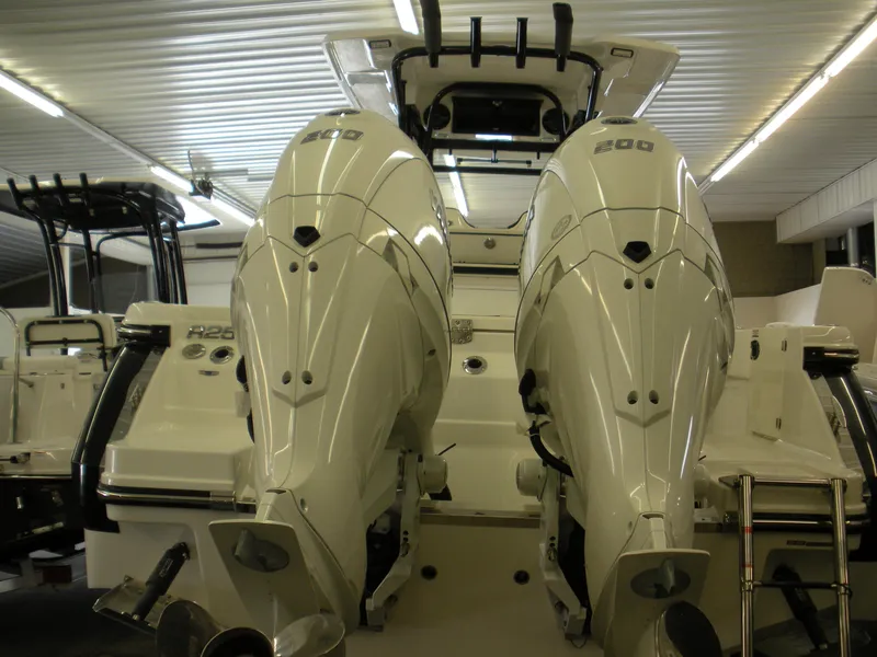 Slide: The Image of 2025 Robalo R250 Center Console with dual outboard engines in a showroom. - 26