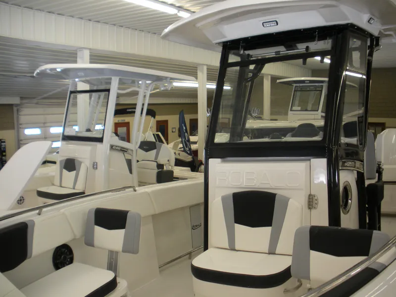 Slide: The Image of 2025 Robalo R250 Center Console boat in showroom, featuring sleek design and modern amenities. - 9