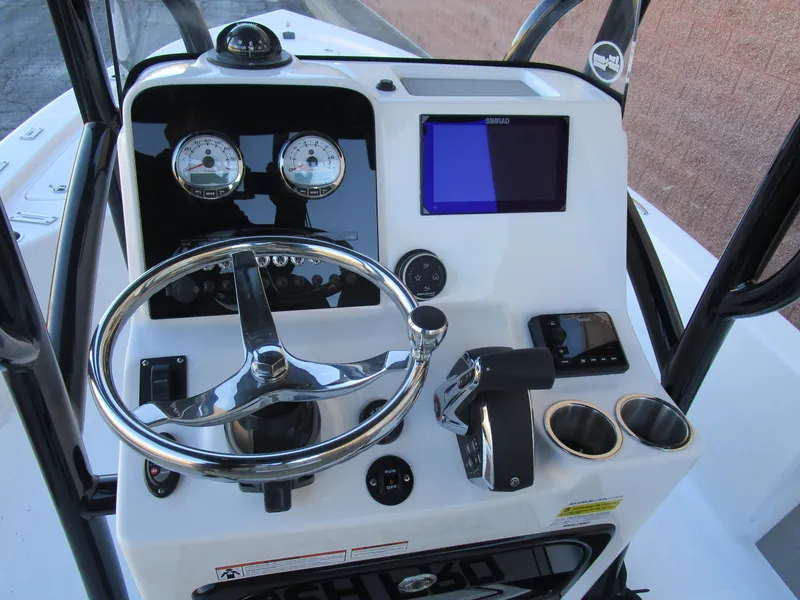 Slide: The Image of 2025 Sea Pro 230 Bay boat dashboard with steering wheel and navigation controls. - 19