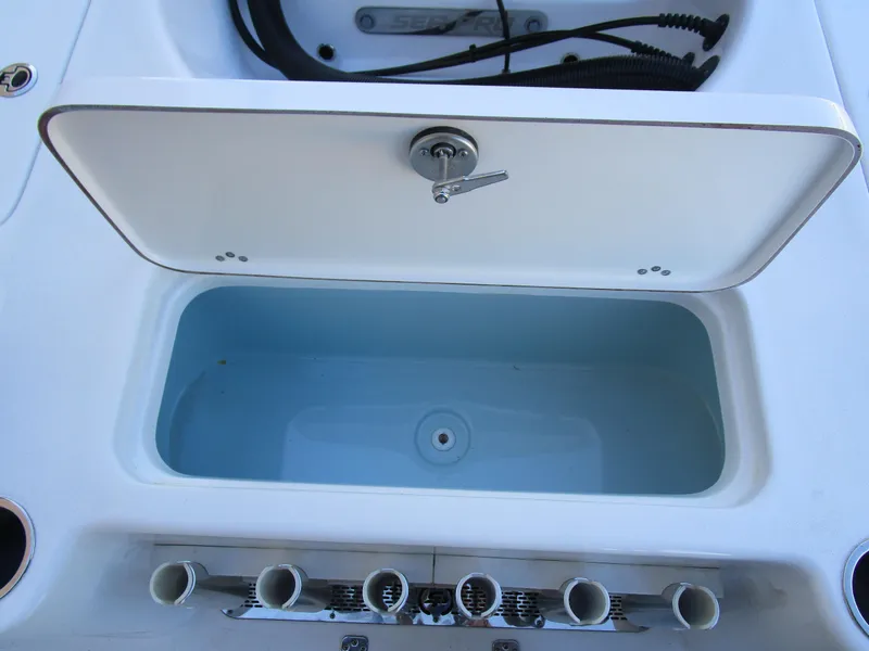 Slide: The Image of Sea Pro 230 Bay 2025 boat storage compartment with rod holders. - 9