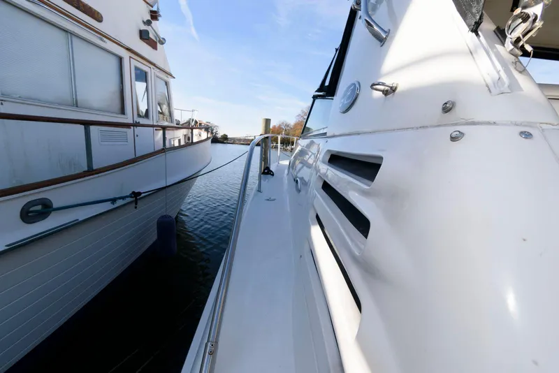 Slide: The Image of 2001 Sea Ray 340 Amberjack docked beside another boat on a sunny day. - 11