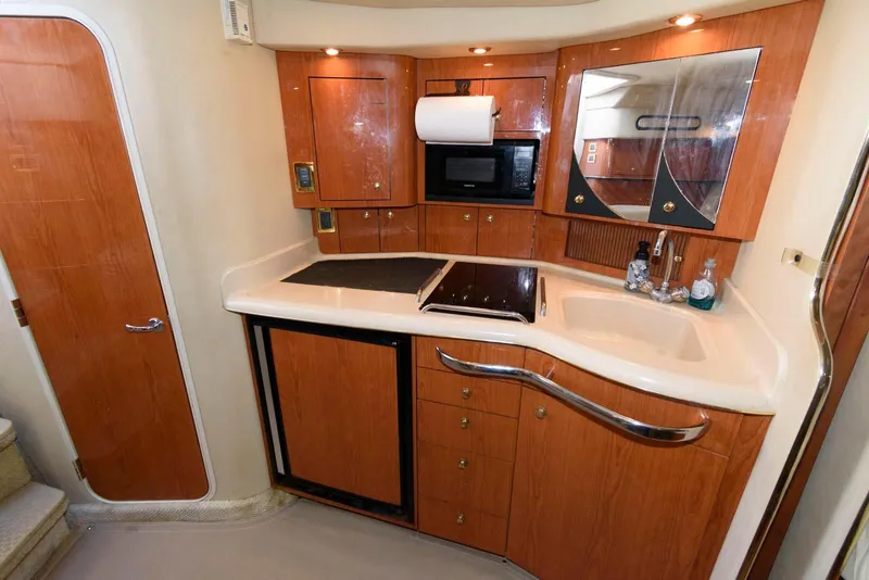 Slide: The Image of 2001 Sea Ray 340 Amberjack yacht kitchen with wood cabinetry and modern appliances. - 14