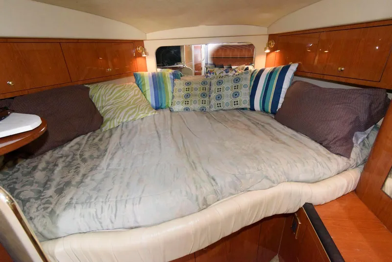 Slide: The Image of Cozy cabin interior of 2001 Sea Ray 340 Amberjack with colorful pillows and wooden cabinetry. - 16