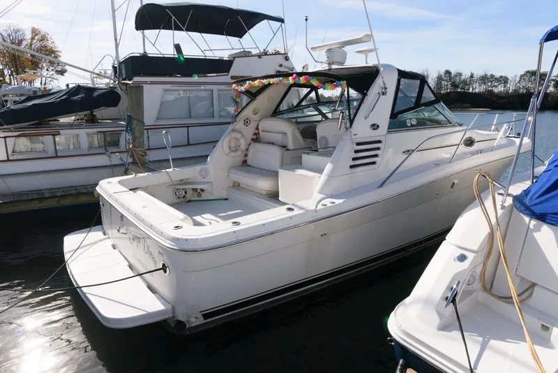 Slide: The Image of 2001 Sea Ray 340 Amberjack boat docked in marina, featuring spacious deck and sleek design. - 2