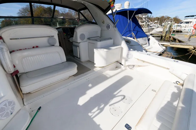 Slide: The Image of 2001 Sea Ray 340 Amberjack boat interior with white seating and docked marina view. - 5