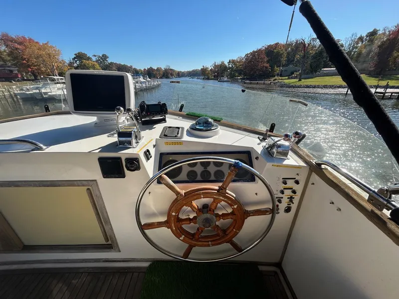 Slide: The Image of Helm of 1986 Grand Banks 42 Classic yacht on a scenic river. - 16