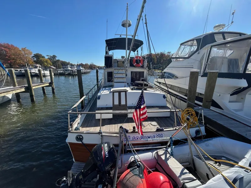 Slide: The Image of 1986 Grand Banks 42 Classic yacht docked at marina with American flag. - 2