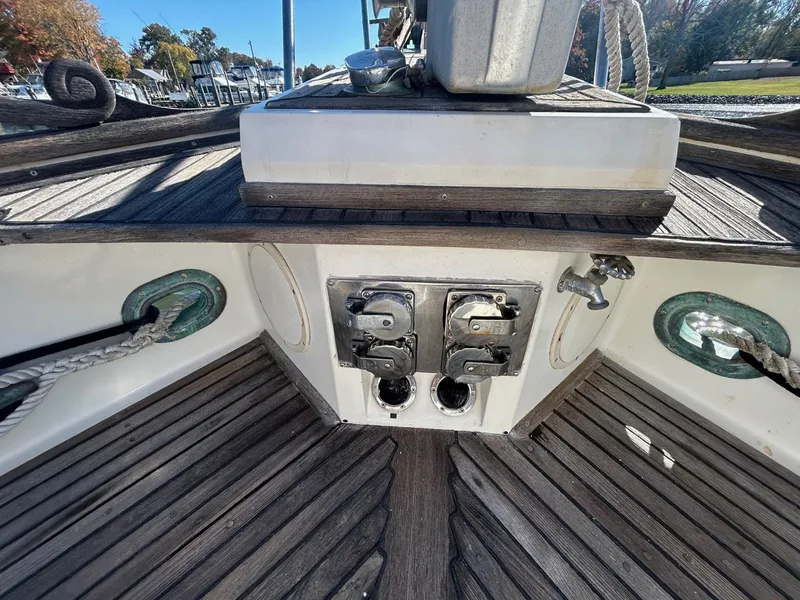 Slide: The Image of 1986 Grand Banks 42 Classic deck with winches and ropes, showcasing teak wood finish. - 21