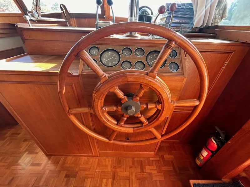 Slide: The Image of Wooden helm of 1986 Grand Banks 42 Classic yacht with gauges and controls. - 30